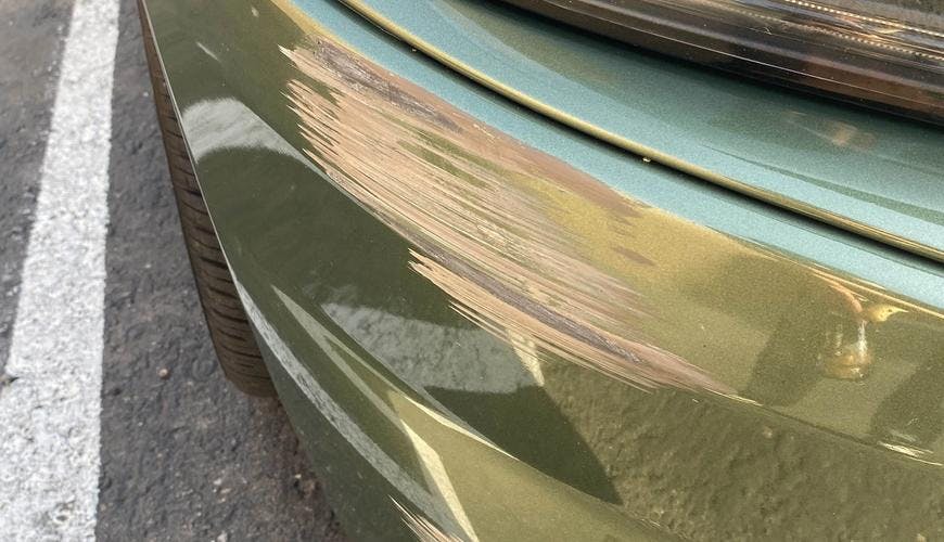 Photograph of damaged Dodge Charger bumper and headlight.