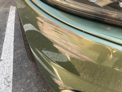 Photograph of damaged Dodge Charger bumper and headlight.